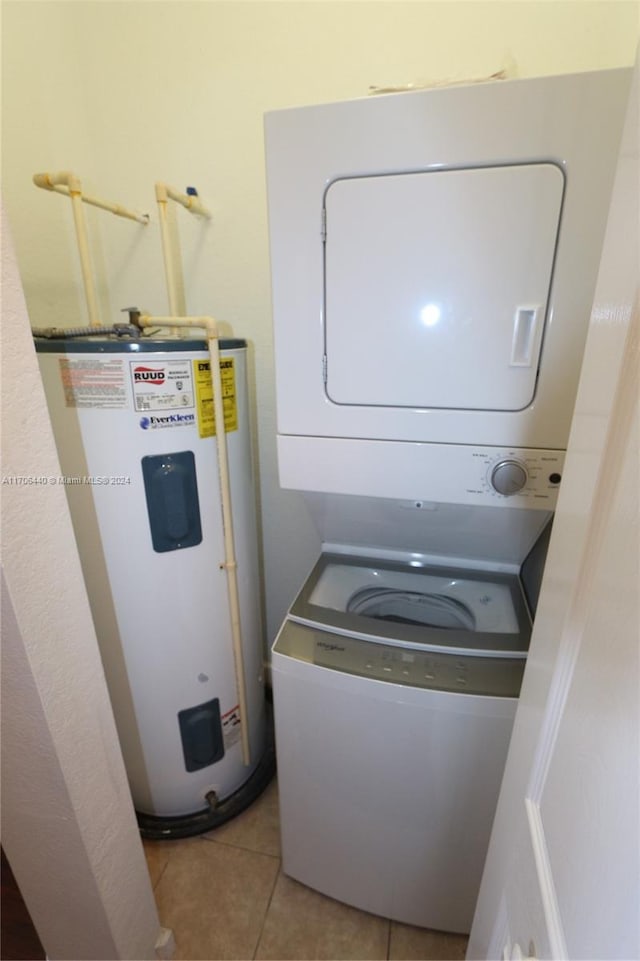 washroom with light tile patterned floors, electric water heater, and stacked washer and dryer