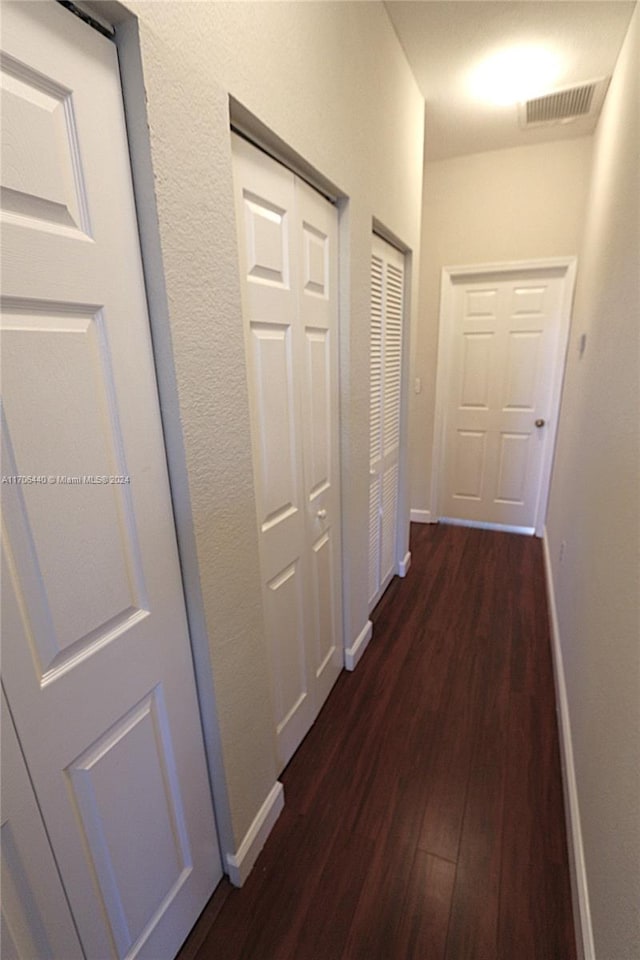 corridor with dark hardwood / wood-style flooring