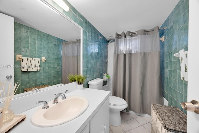 bathroom featuring tile patterned flooring, vanity, toilet, and tile walls