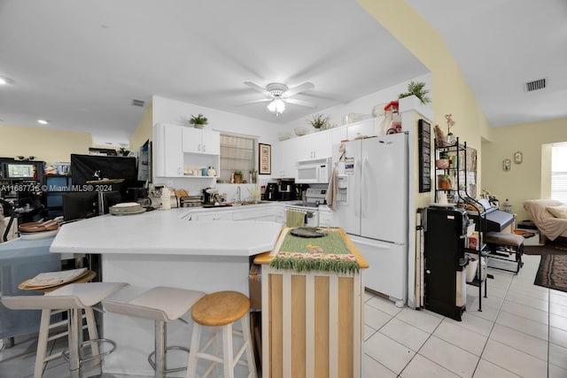 kitchen with kitchen peninsula, a breakfast bar, white appliances, ceiling fan, and white cabinetry