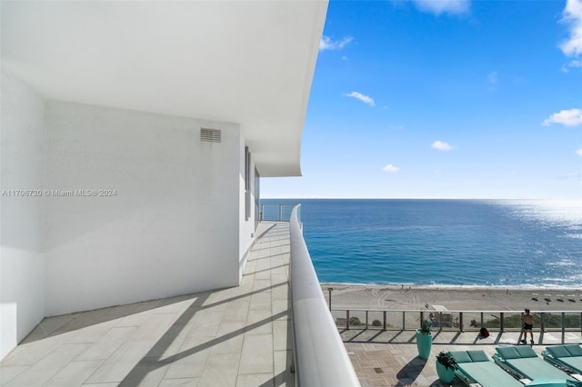 balcony featuring a beach view and a water view