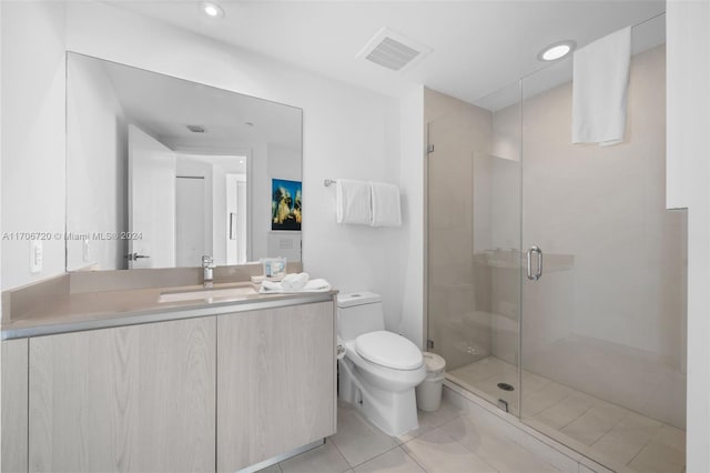 bathroom featuring tile patterned flooring, vanity, toilet, and walk in shower