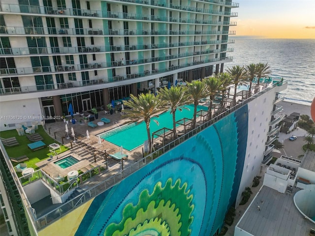 pool at dusk featuring a water view