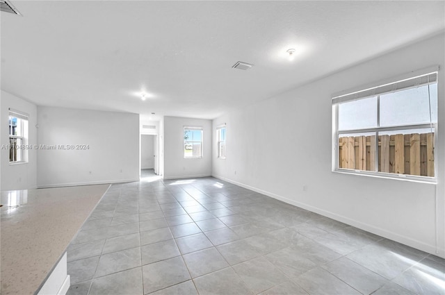 spare room featuring light tile patterned flooring