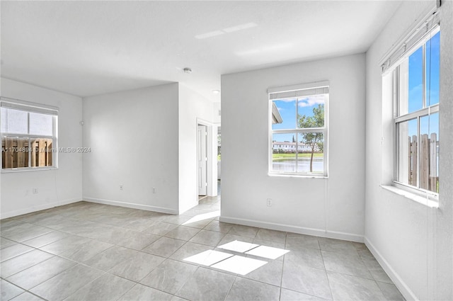 spare room with a healthy amount of sunlight and light tile patterned flooring