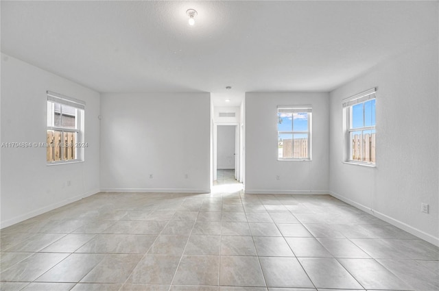 spare room with light tile patterned flooring and a healthy amount of sunlight