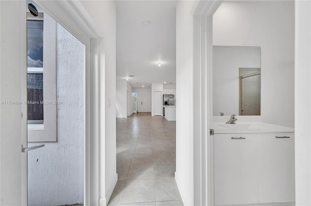 corridor with light tile patterned floors and sink