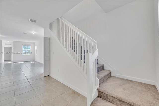 stairway featuring tile patterned flooring