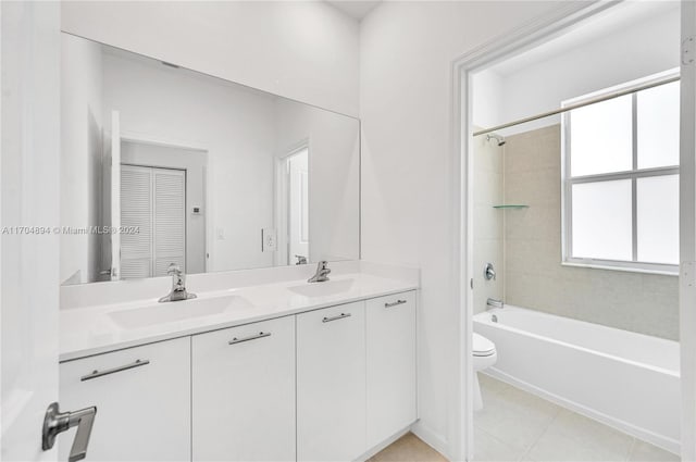 full bathroom with tiled shower / bath, tile patterned flooring, vanity, and toilet