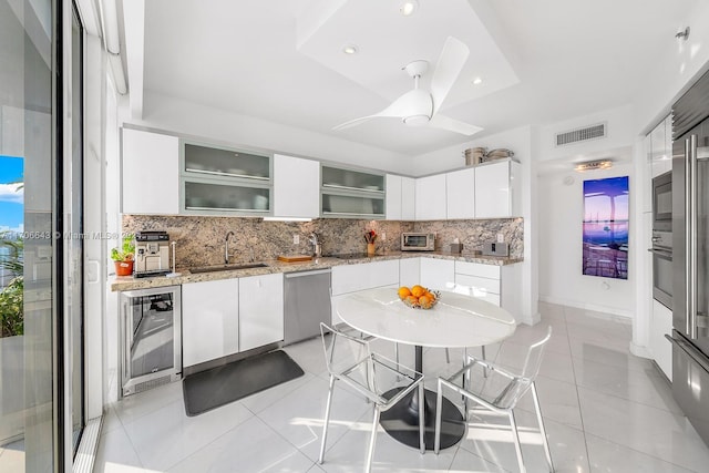 kitchen featuring sink, tasteful backsplash, wine cooler, white cabinets, and appliances with stainless steel finishes