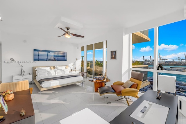 bedroom featuring ceiling fan, expansive windows, a water view, and light tile patterned floors