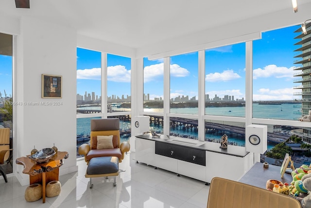 sunroom featuring a water view