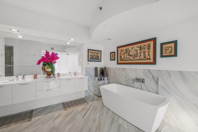 bathroom with separate shower and tub, vanity, and tile walls