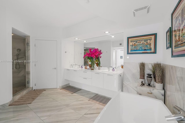 bathroom with vanity and independent shower and bath