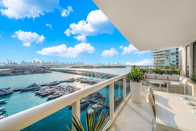 balcony featuring an outdoor living space and a water view