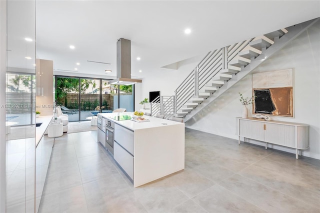 kitchen with a center island, white cabinets, oven, radiator heating unit, and island exhaust hood