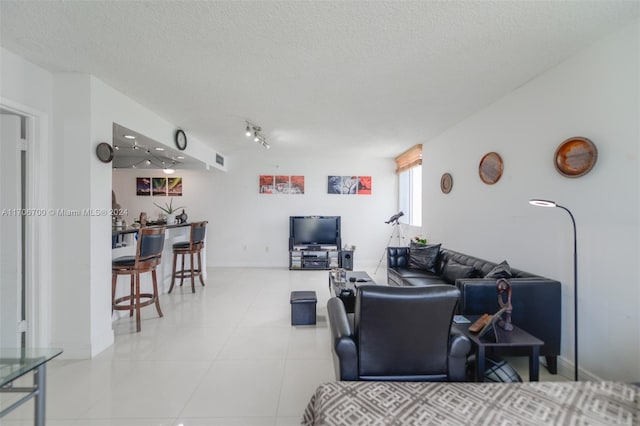 living room featuring a textured ceiling and light tile patterned flooring