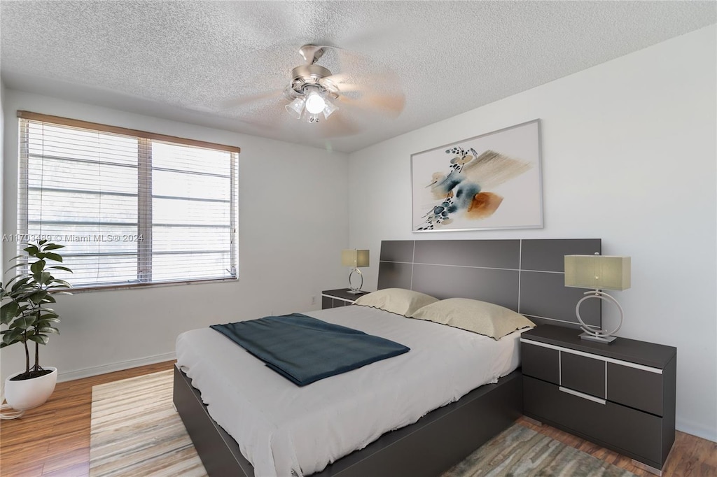 bedroom featuring a textured ceiling, hardwood / wood-style flooring, and ceiling fan