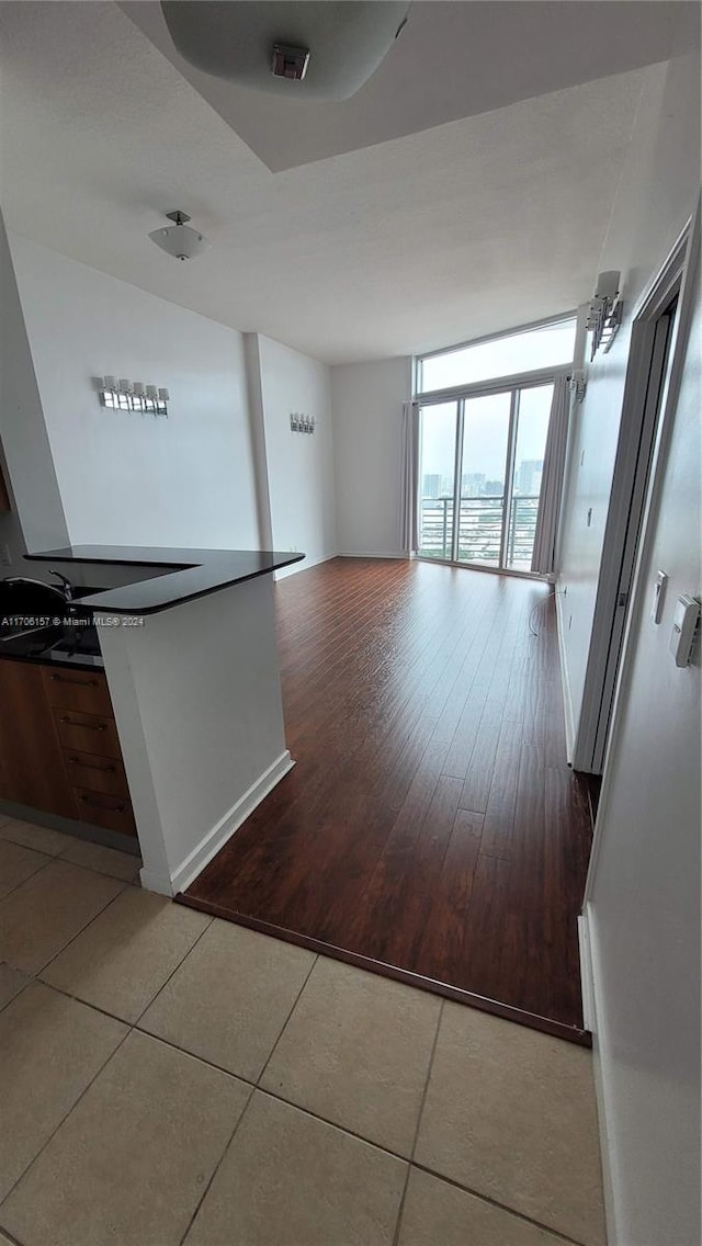 unfurnished living room with hardwood / wood-style floors and a wall of windows