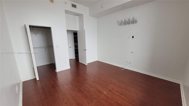 unfurnished bedroom featuring dark hardwood / wood-style flooring and a closet