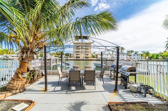 view of patio with a grill and a water view