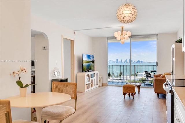 dining room featuring expansive windows, light hardwood / wood-style floors, and an inviting chandelier