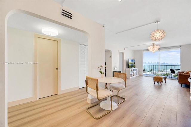 interior space featuring floor to ceiling windows, light hardwood / wood-style flooring, and a notable chandelier