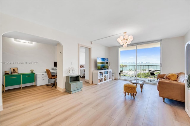 living room featuring light wood-type flooring, expansive windows, and a notable chandelier