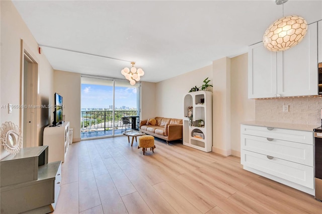 living room featuring a chandelier, expansive windows, and light hardwood / wood-style floors