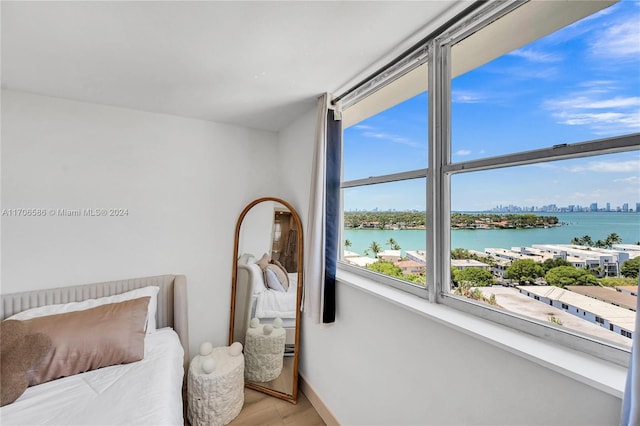 bedroom featuring a water view and light wood-type flooring