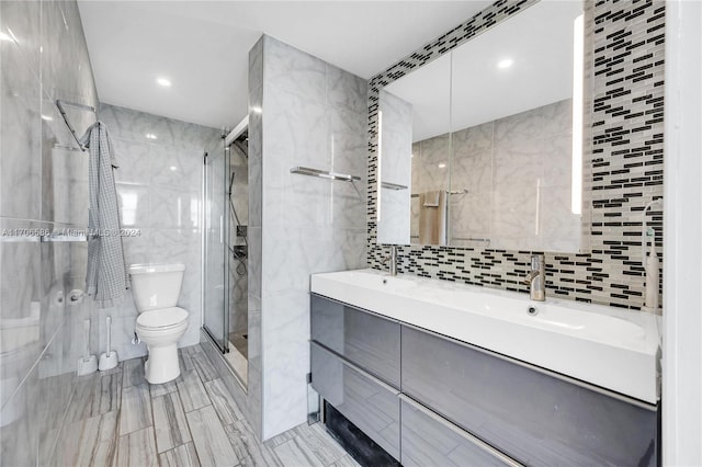 bathroom with walk in shower, vanity, tile walls, and toilet