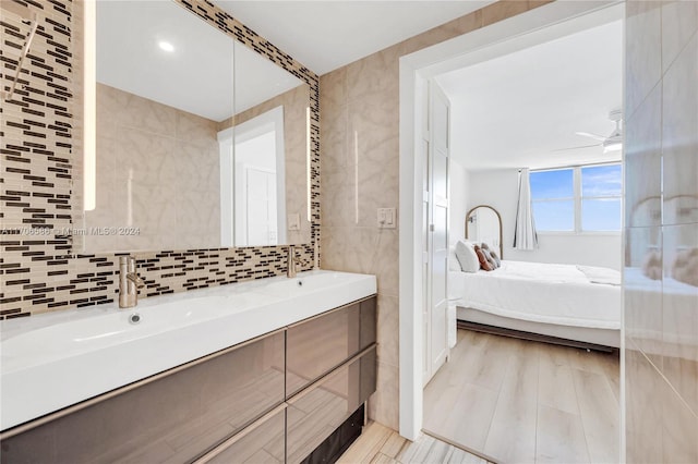 bathroom featuring vanity, tasteful backsplash, tile walls, and ceiling fan