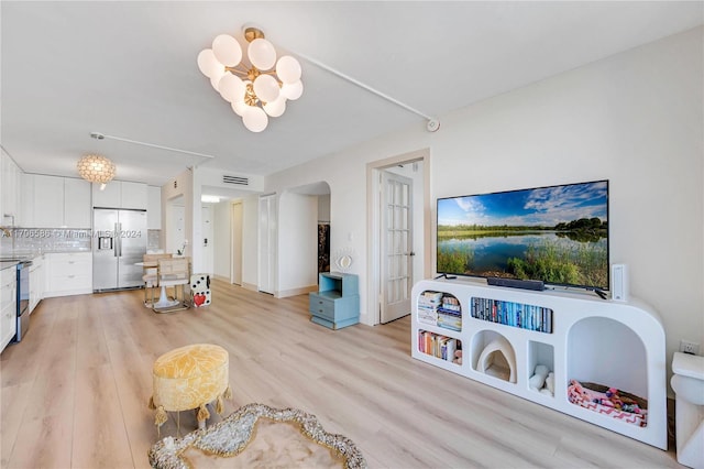 living room with a notable chandelier and light hardwood / wood-style flooring