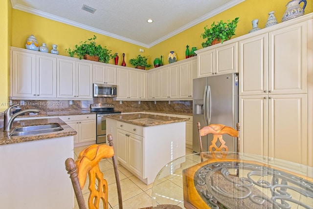 kitchen with decorative backsplash, stainless steel appliances, crown molding, and sink