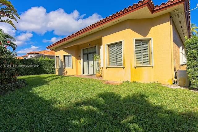 back of property featuring a lawn