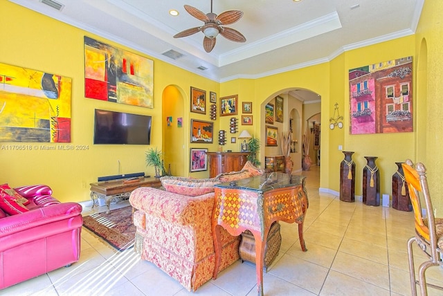 tiled living room featuring a raised ceiling, ceiling fan, and ornamental molding