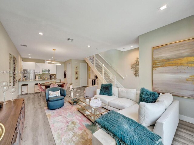 living room featuring ceiling fan and light wood-type flooring