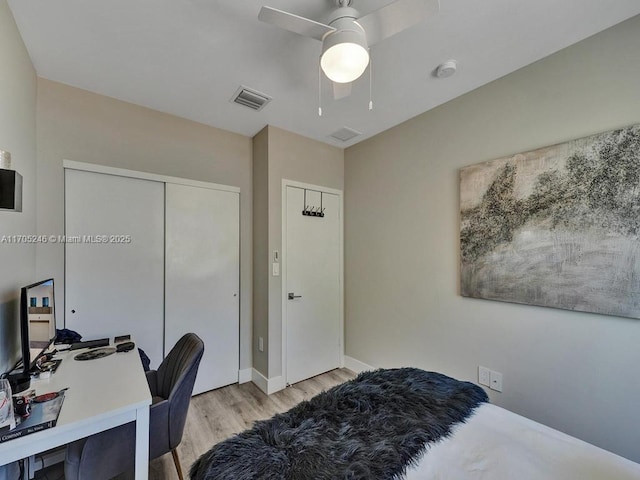 bedroom with light hardwood / wood-style flooring, a closet, and ceiling fan