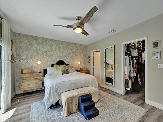 bedroom with wood-type flooring, access to outside, and ceiling fan