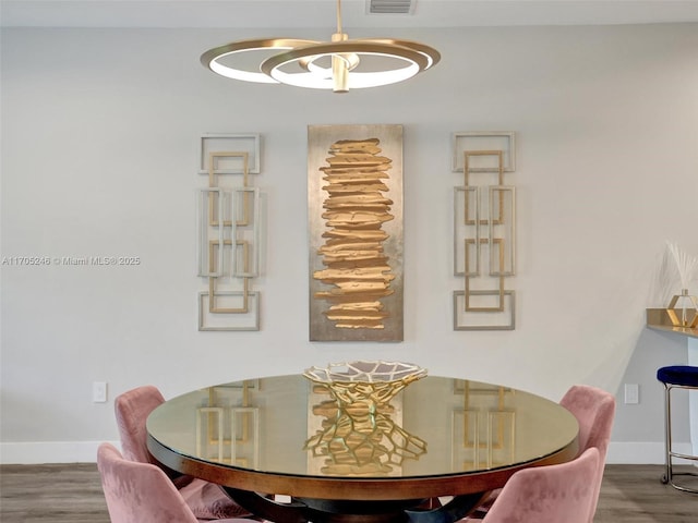 dining room with hardwood / wood-style floors and a notable chandelier