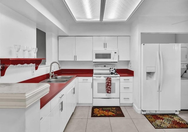 kitchen with white cabinetry, sink, light tile patterned floors, and white appliances