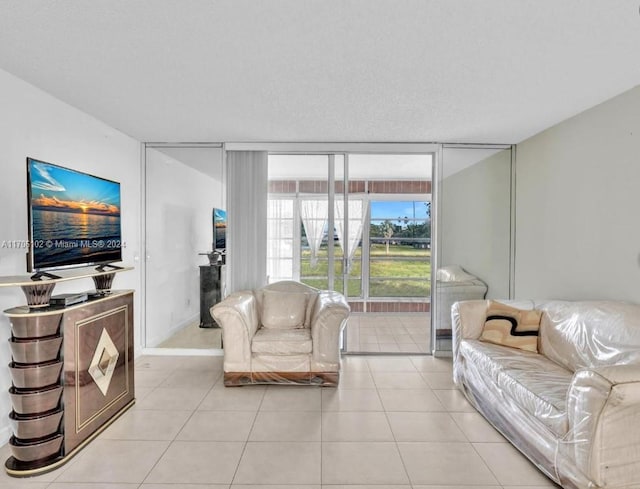 living room with floor to ceiling windows, light tile patterned floors, and a textured ceiling