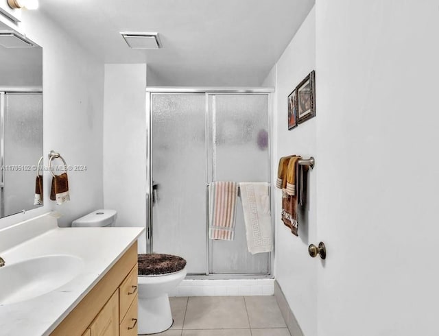 bathroom featuring tile patterned flooring, vanity, toilet, and walk in shower