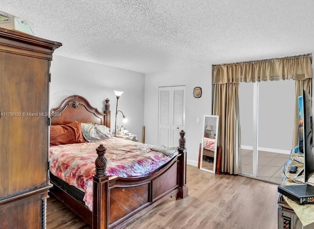 bedroom featuring a closet, hardwood / wood-style floors, and a textured ceiling