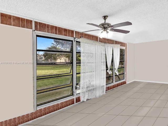 unfurnished sunroom with ceiling fan