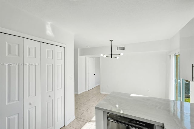 kitchen featuring a textured ceiling, a notable chandelier, light tile patterned flooring, and hanging light fixtures