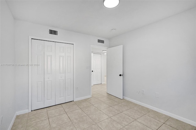 unfurnished bedroom featuring a closet and light tile patterned floors