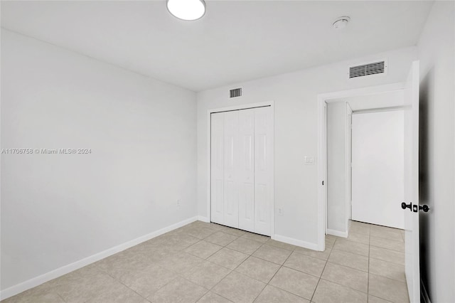 unfurnished bedroom featuring light tile patterned floors and a closet