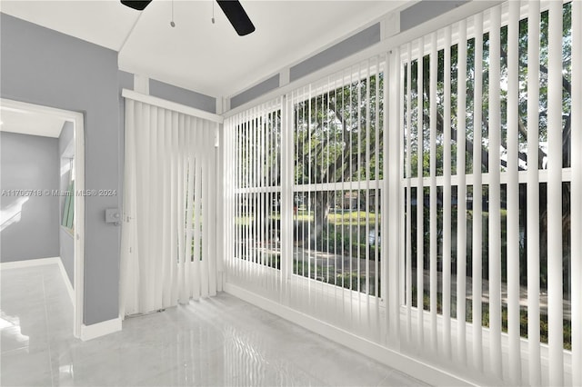 unfurnished sunroom featuring ceiling fan