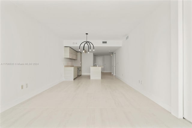 unfurnished living room featuring light tile patterned floors and an inviting chandelier